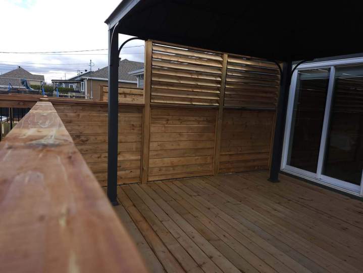 Terrasse extérieure en Canexel avec une pergola et des panneaux d'intimité à lattes horizontales, Lévis